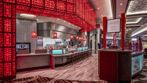 A modern bar area with red decor, a counter, and seating. - Horseshoe Lake Charles Hotel & Casino -  A Caesars Rewards Destination (Westlake)