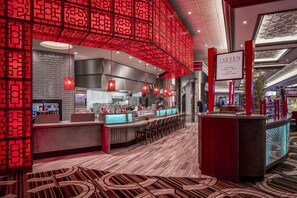 A modern bar area with red decor, a counter, and seating. - Horseshoe Lake Charles Hotel & Casino -  A Caesars Rewards Destination (Westlake)