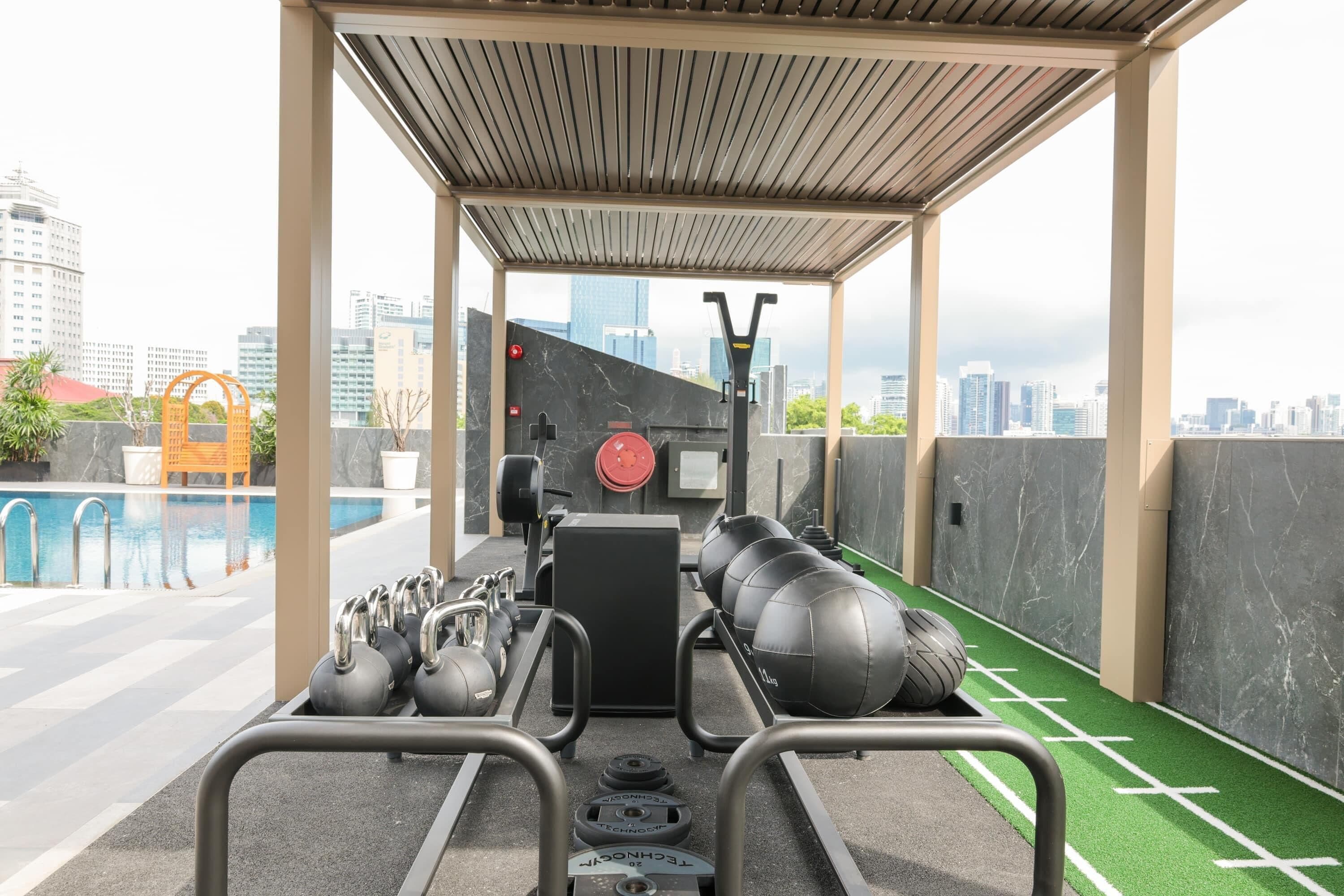Gimnàs a l'aire lliure cobert amb kettlebells, una pica d'esquiva i discs de pes.