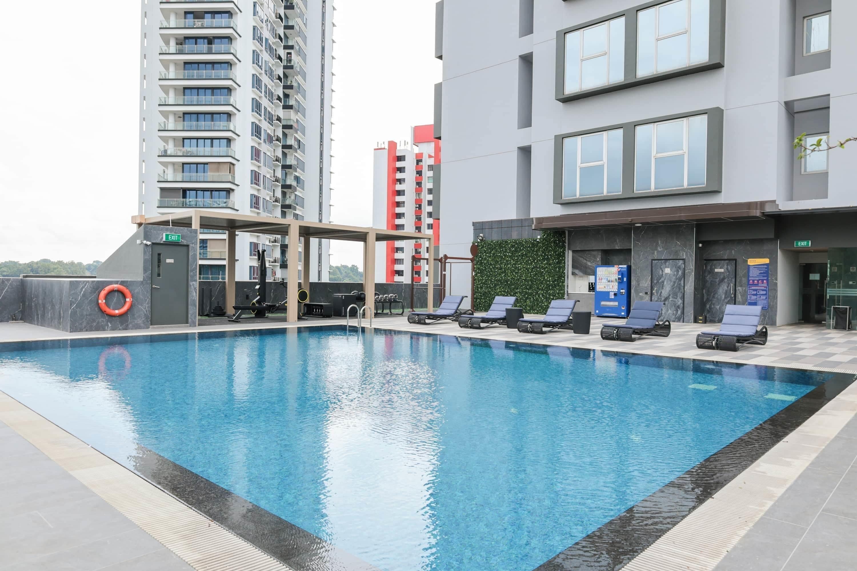 A swimming pool with lounge chairs, a lifebuoy, and a covered area.
