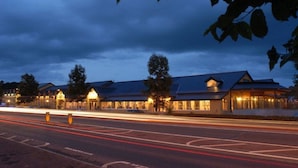 A hotel with multiple buildings, each featuring a distinct architectural style with sloped roofs and illuminated windows. - Abbeyleix Manor Hotel (Abbeyleix)
