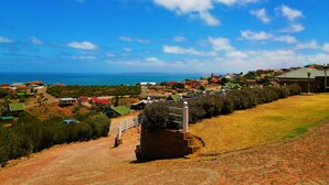 Un pueblo costero con casas, un sendero pavimentado y vistas al mar.