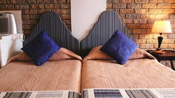 Un letto matrimoniale con testiera in legno, due cuscini e una coperta.