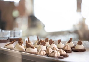 A dessert tray with meringue-topped cookies and chocolate pieces.