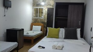 A hotel room with a bed, a desk, a television, and a wardrobe. - Beach Hotel Jacumã (Conde)