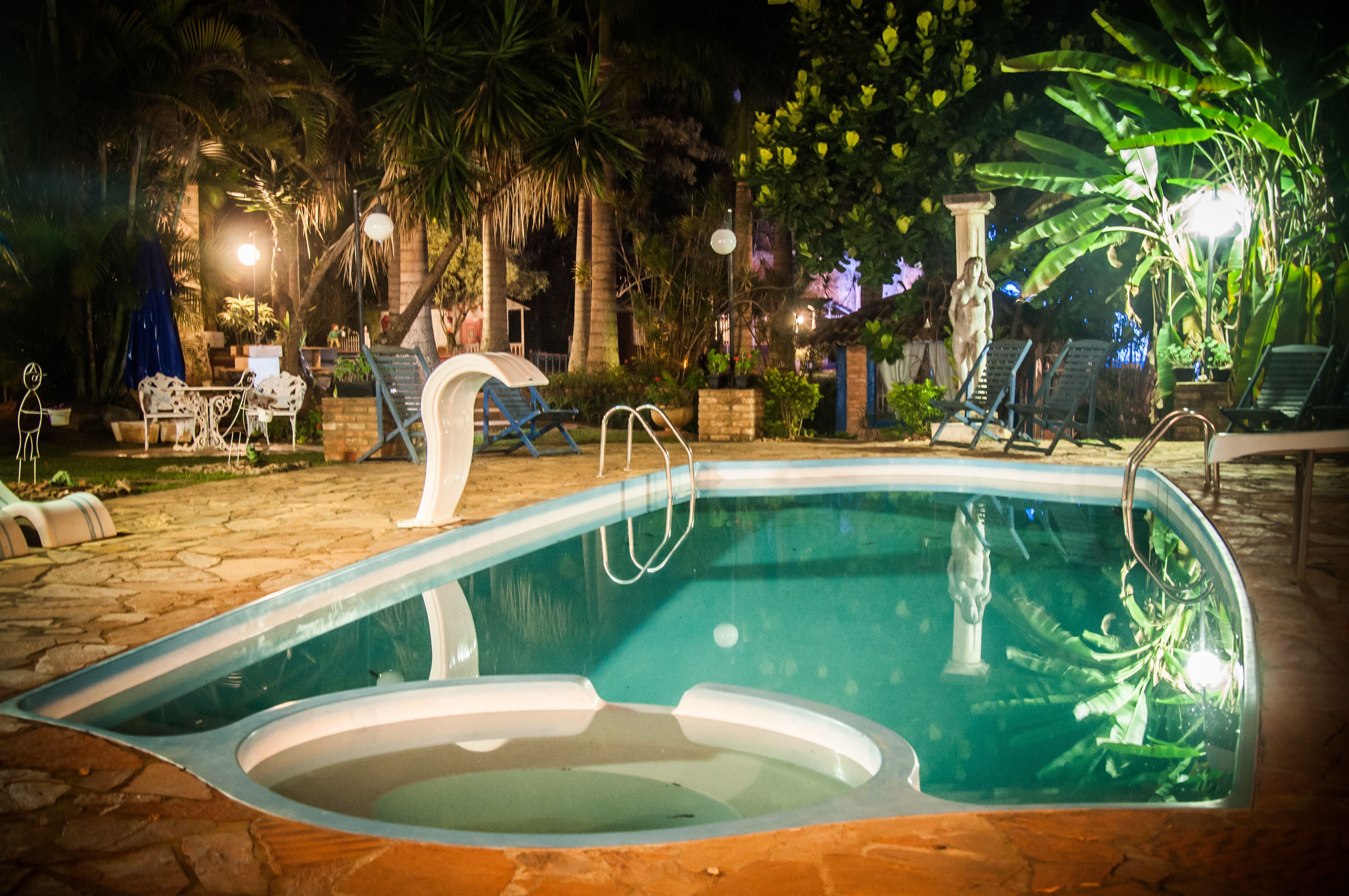 Una piscina al aire libre, sombrillas, sillones reclinables de piscina
