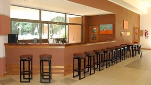 Una zona de bar con varios taburetes y una barra.