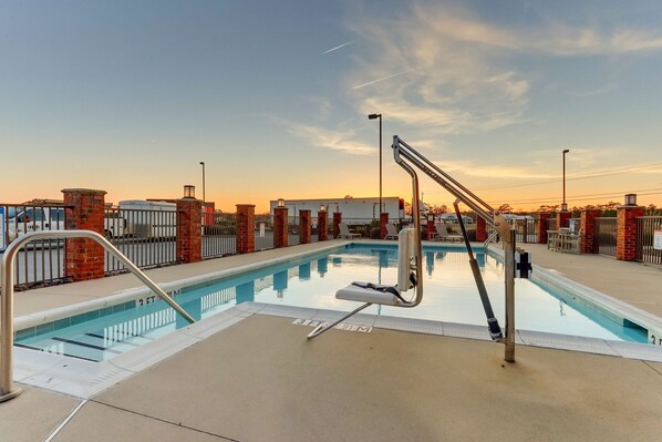 A swimming pool with a diving board and a lifeguard stand.