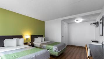 A hotel room with two beds, a desk, and a chair.