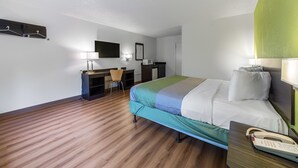 A hotel room with a bed, desk, chair, and a telephone on a table. - Motel 6 Warminster, PA (Warminster)