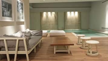 Una piscina techada, sillones reclinables de piscina