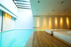 Una piscina techada, sillones reclinables de piscina