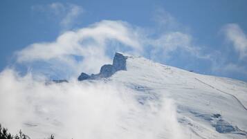 Een met sneeuw bedekte berg met een heldere lucht en wolken.