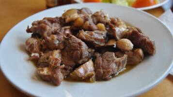 A plate of cooked meat with onions and possibly other vegetables.