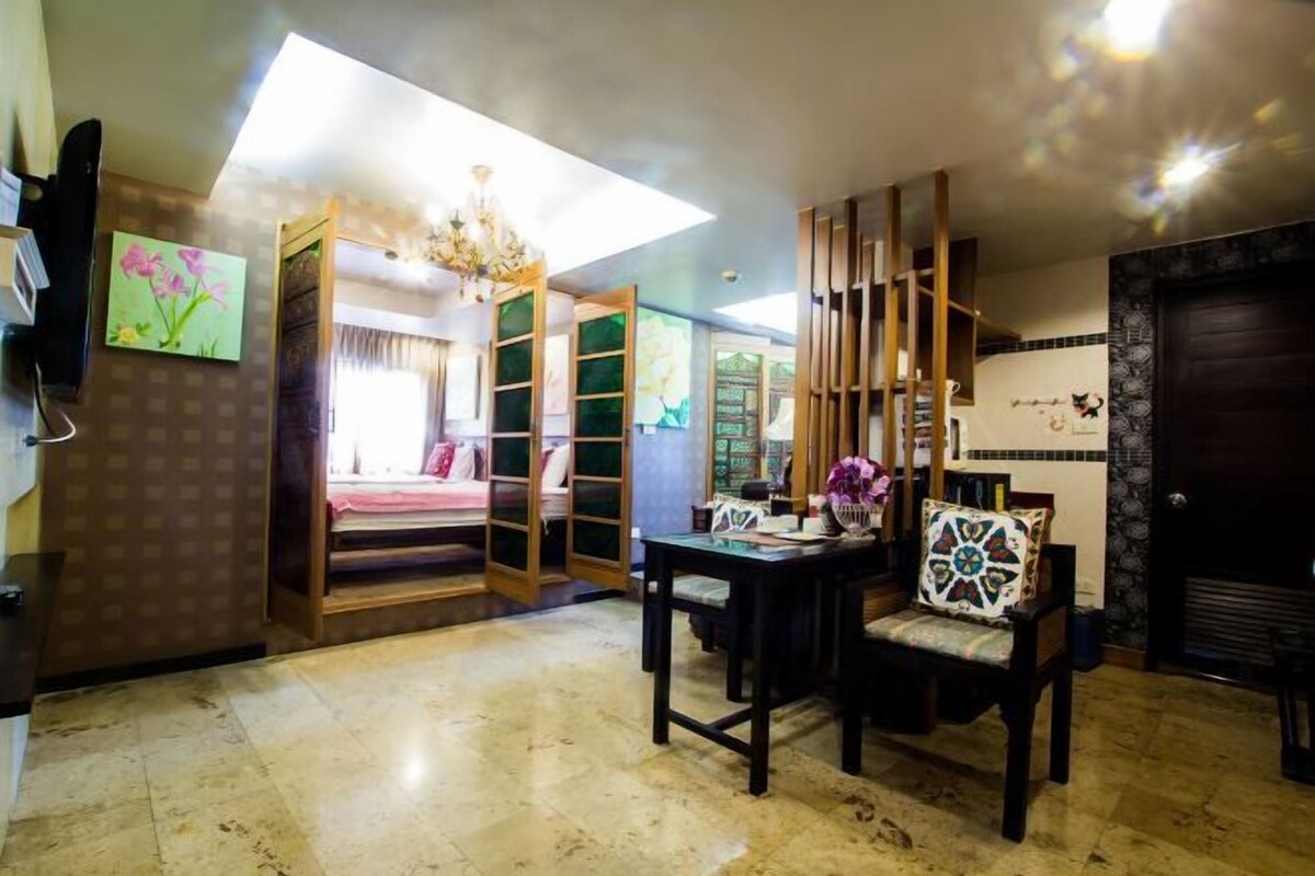 Una habitación con cama, escritorio, silla y estantería.