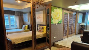 A bedroom with two beds, a large window, and a view of the outside. - Sabai Sabai @ Sukhumvit Hotel (Bangkok)