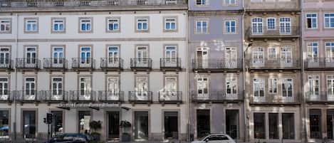 A row of historic buildings with balconies and a hotel named "Camis Hotels Porto Ribeiro" in the center.
