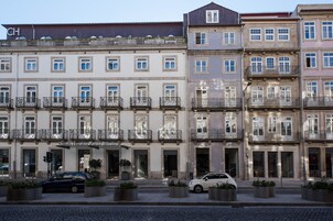 A row of historic buildings with balconies and a hotel named "Camis Hotels Porto Ribeiro" in the center.