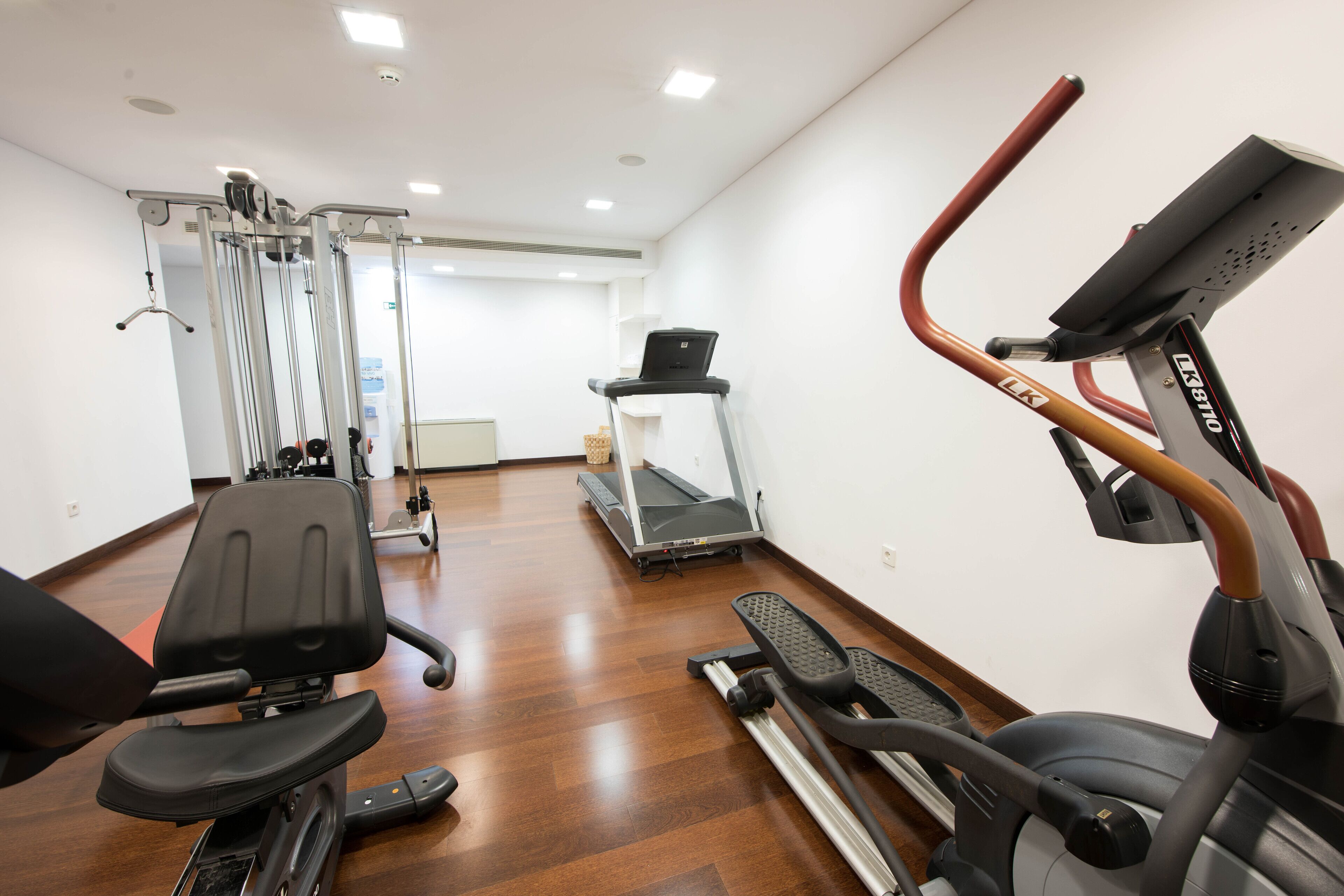 A gym with exercise equipment including a treadmill, stationary bike, and weight machines.