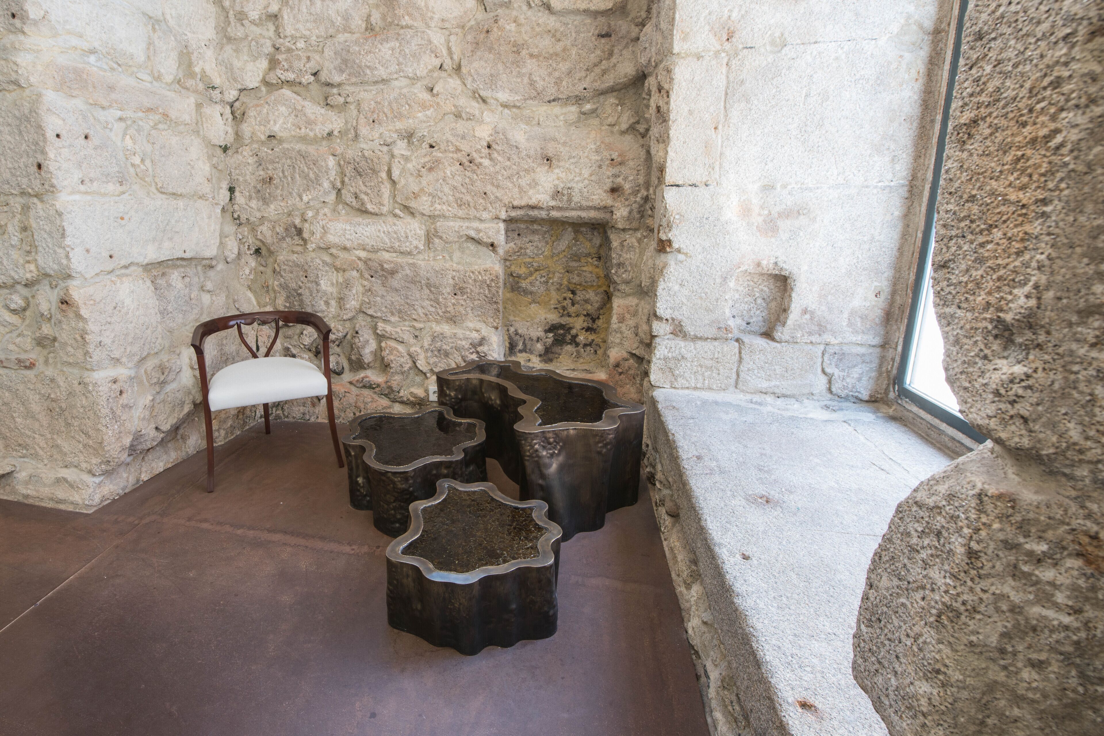 A stone-walled room with a wooden chair and star-shaped stools.