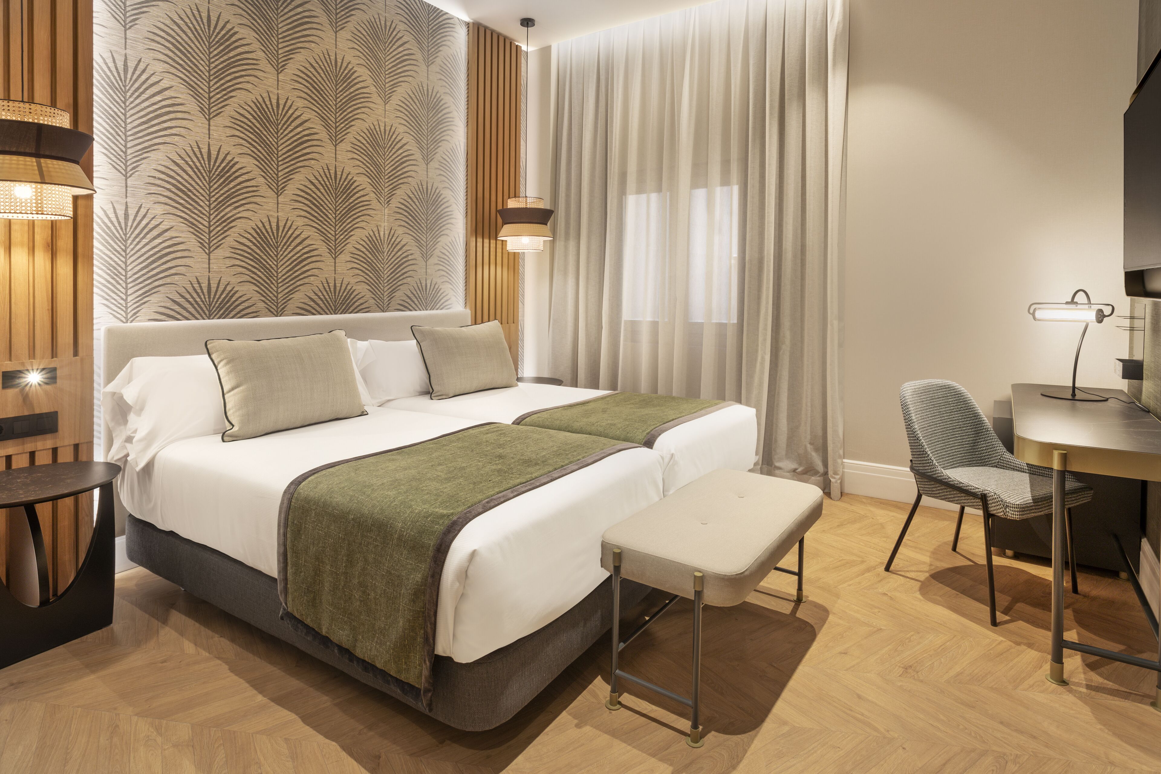 Ein modernes Hotelzimmer mit einem großen Bett, einem Schreibtisch, einem Stuhl und einem Fernseher.