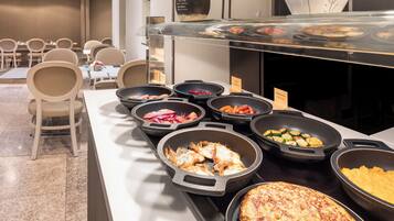 Un bufé con diversos platos, como tortillas y verduras, en un ambiente de hotel.
