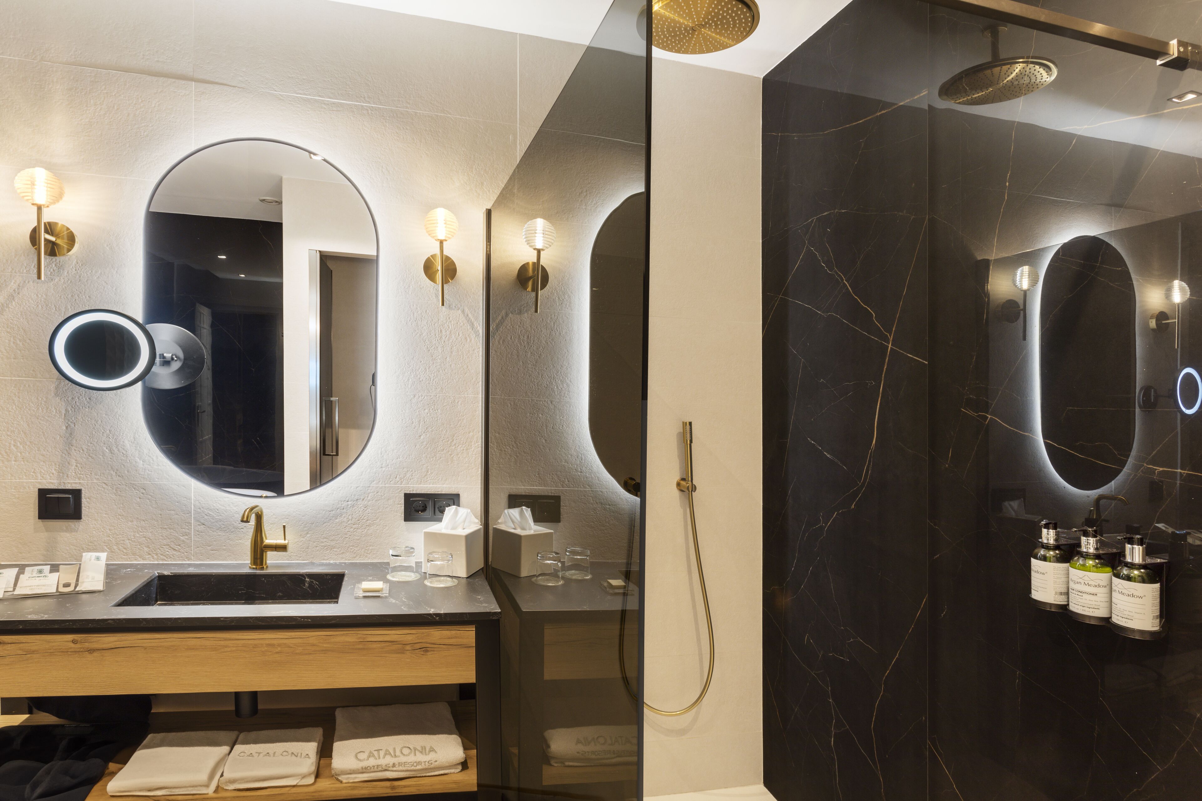 A modern bathroom with a vanity, mirror, and shower.
