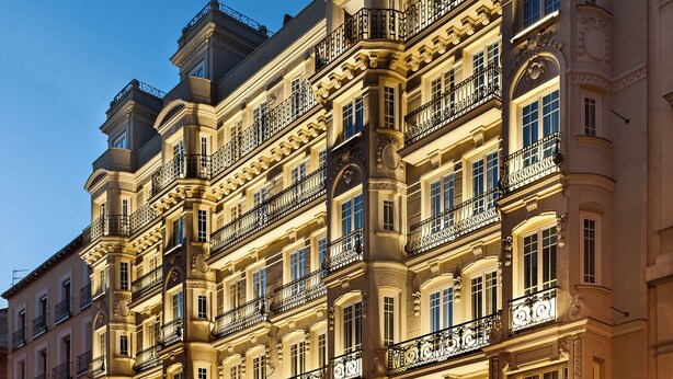 Un hotel de varios pisos con balcones ornamentados y ventanas amplias.