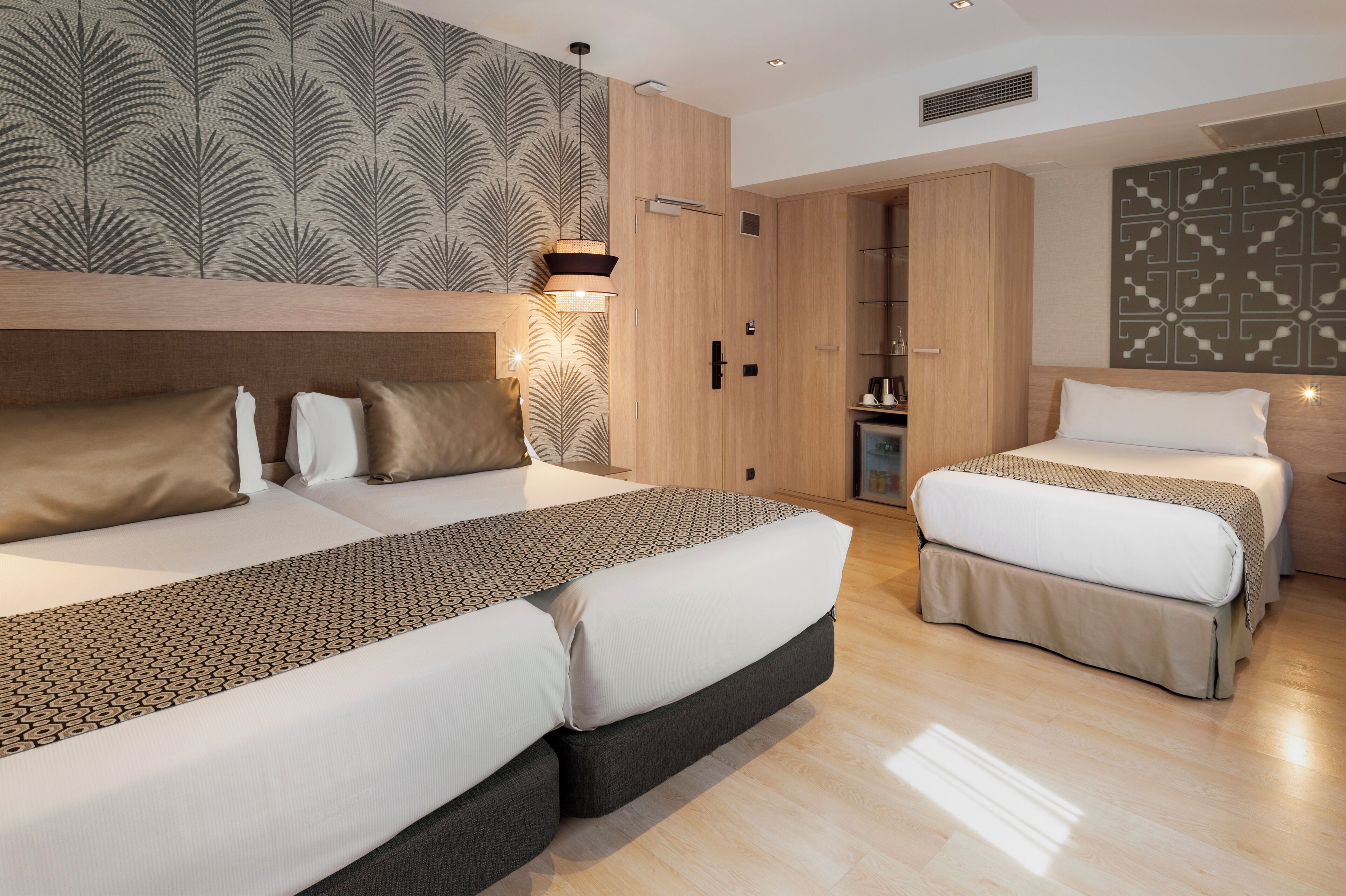 Ein modernes Hotelzimmer mit zwei Betten, einem Kleiderschrank, einem Schminktisch und einem Badezimmer.