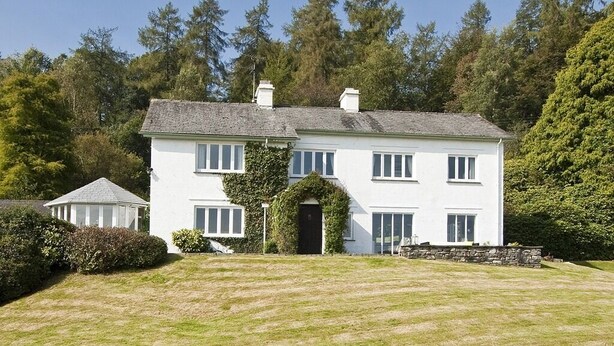 A two-story white house with a symmetrical facade, a central entrance, and a small garden area in front. - High Grassings Country House (Ambleside)