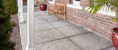 A covered outdoor area with a wooden ceiling, brick walls, and a bench.