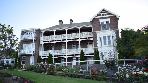 A large, multi-story building with a prominent balcony and a corner turret. - Auldington Hotel (Launceston)