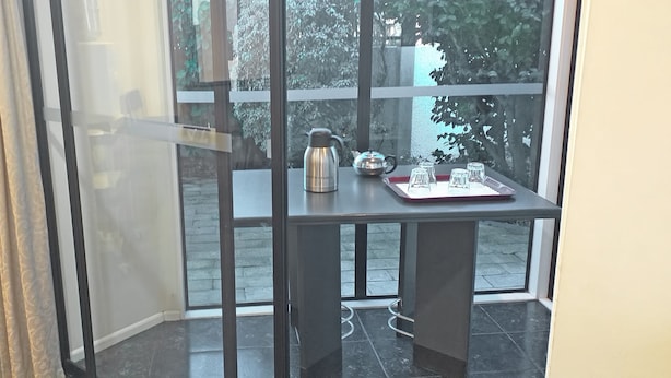 Habitación de esquina con una mesa dispuesta para tomar té, una tetera y vasos.