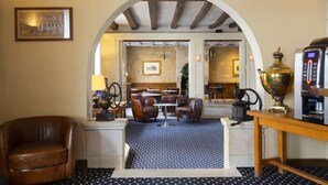 A lobby with leather chairs, a coffee machine, and a table with a brass urn.