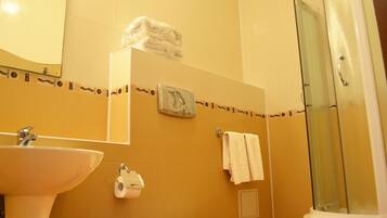 A bathroom with a sink, toilet, and shower.