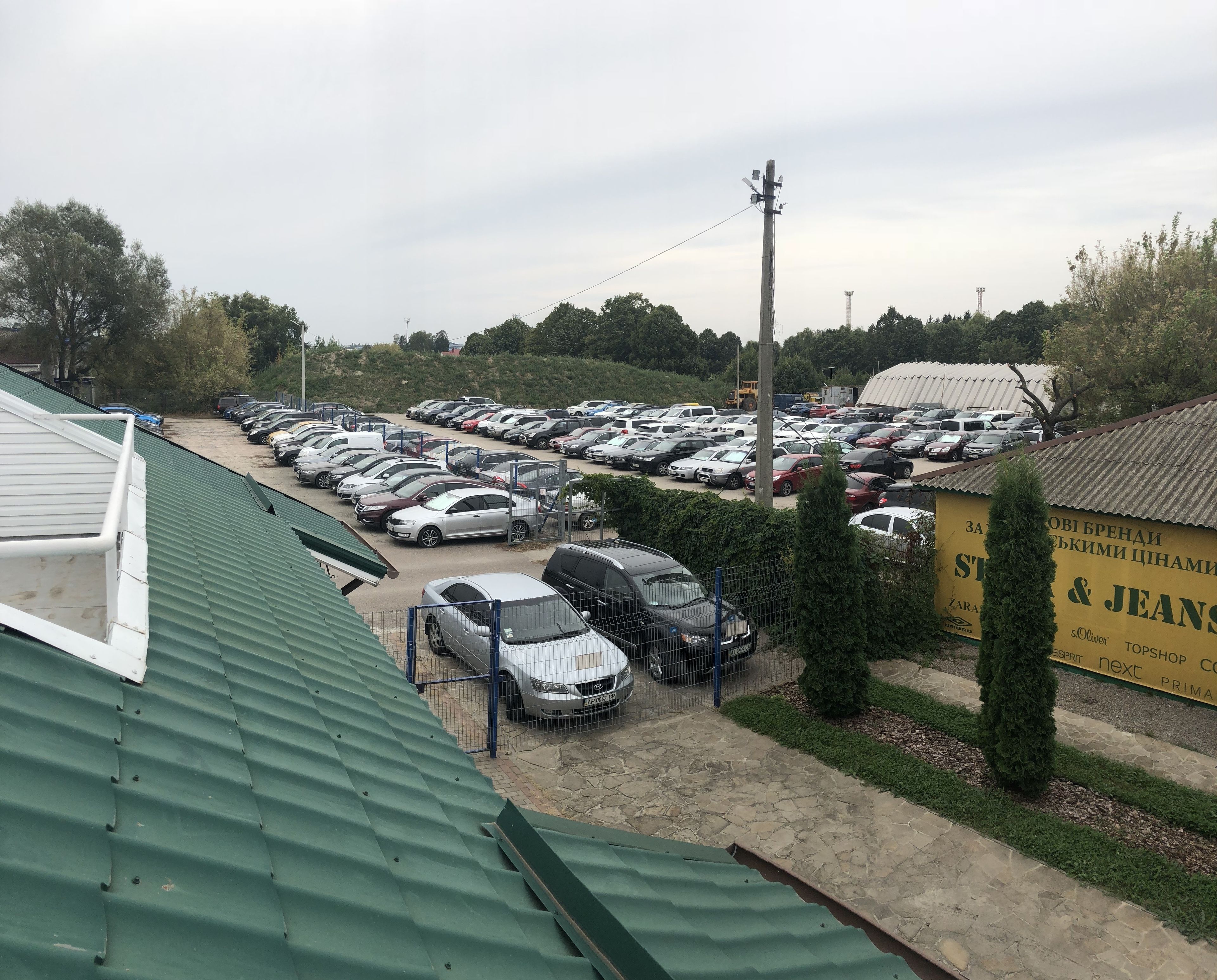 A parking lot with multiple cars and a building with signage.
