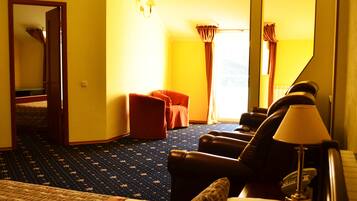 Habitación de hotel con una cama, una silla, una mesita y un espejo.