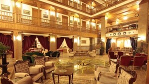 A spacious lobby with a central glass coffee table, multiple seating areas, and a high ceiling with ornate woodwork. - Kerme Ottoman Palace - Boutique Class (Ula)
