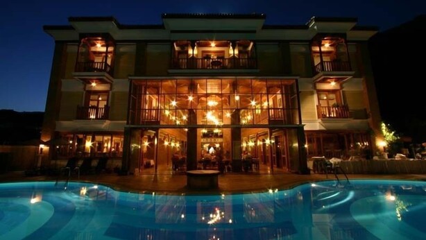 A multi-story hotel with a swimming pool in front. - Kerme Ottoman Palace - Boutique Class (Ula)
