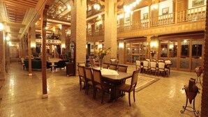 A spacious lobby with a high ceiling, wooden columns, and a central dining area with tables and chairs. - Kerme Ottoman Palace - Boutique Class (Ula)