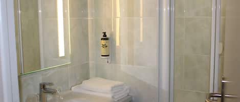 Un baño con lavamanos, espejo y ducha.
