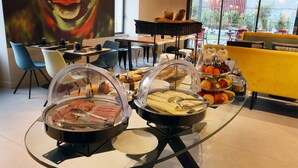 A breakfast buffet with various food items and a large window with a view of the outdoors. - Hôtel  la Capelle (Millau)