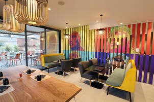 Un interior moderno con una mesa de comedor de madera, asientos acolchados y paneles verticales coloridos.