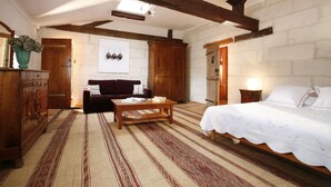 A room with a bed, wooden furniture, a patterned rug, and a white wall with a framed picture. - La Porte Rouge - The Red Door Inn Chambres d'Hotes (Saintes)