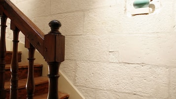 A wooden staircase with a handrail leading to a landing.
