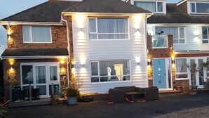 Een herenhuis met een voortuin, een blauwe deur en een klein terras.