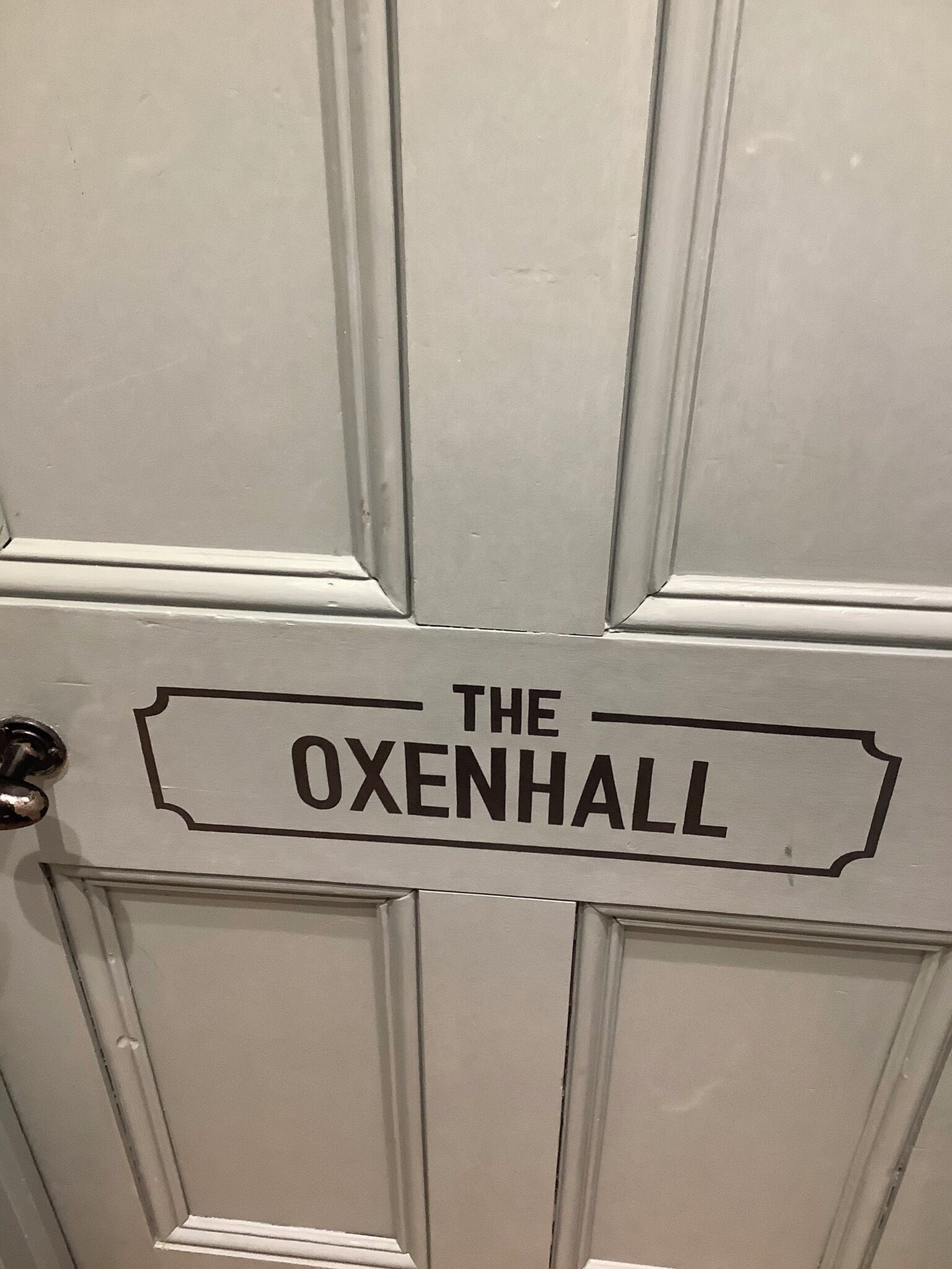 A door with a sign that reads "THE OXENHALL".