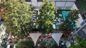 An aerial view of a rooftop garden with trees, outdoor seating, and a swimming pool.
