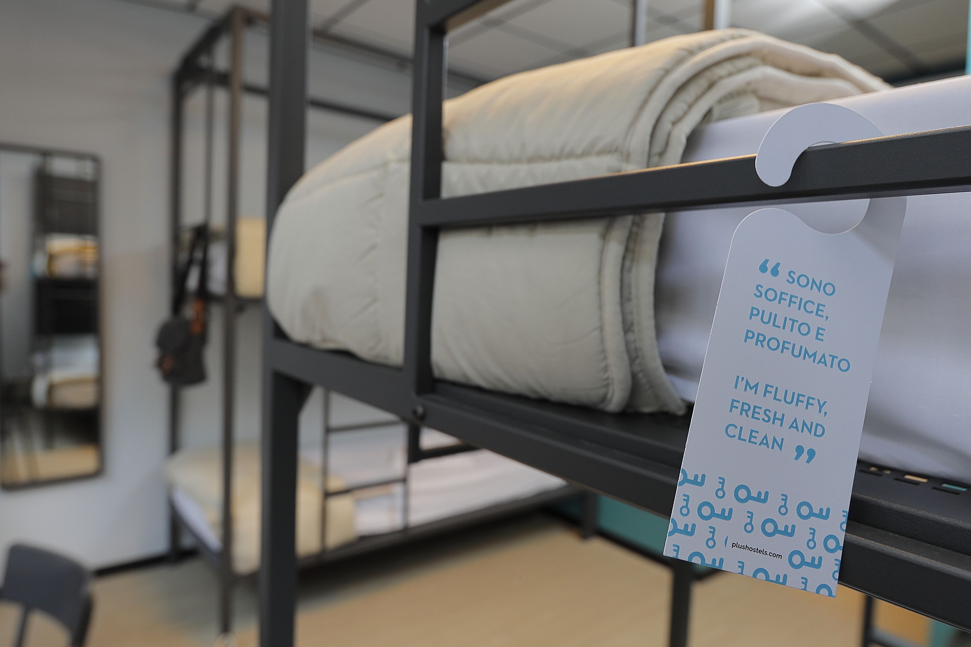 Camas literas con una etiqueta que describe la ropa de cama como esponjosa, fresca y limpia.