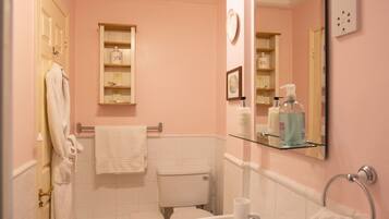 A bathroom with a white sink, a toilet, a mirror, and a towel rack.